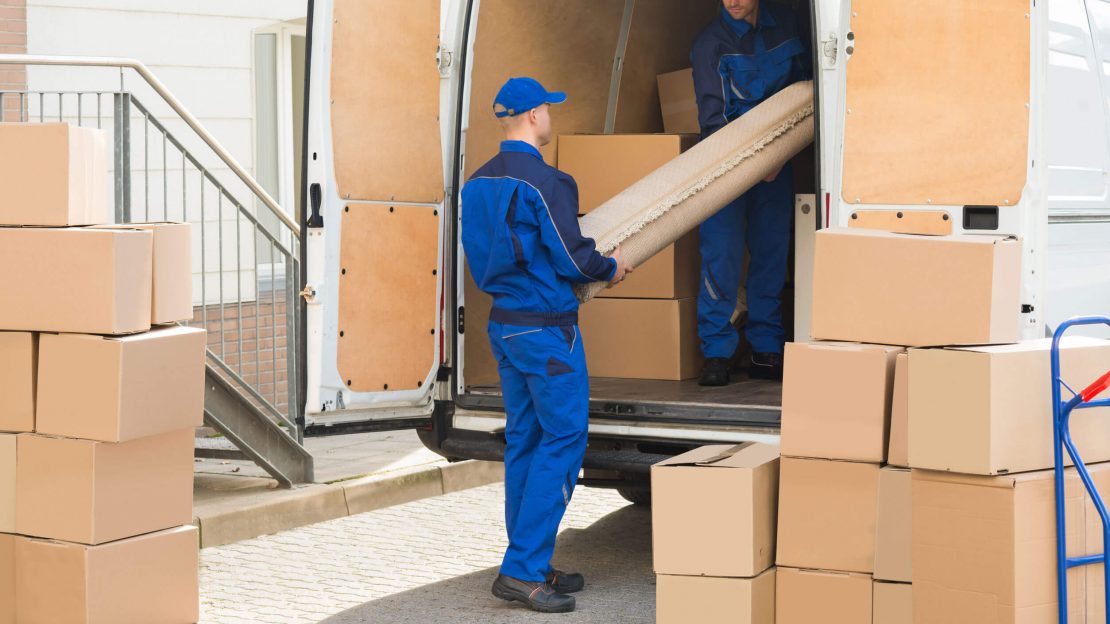 Movers Unloading Rolled Up Rug From Truck