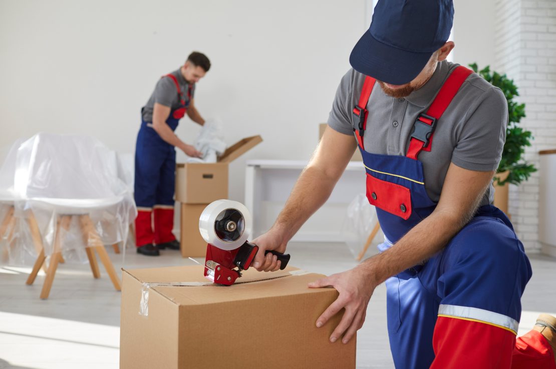 Movers taping a packed box